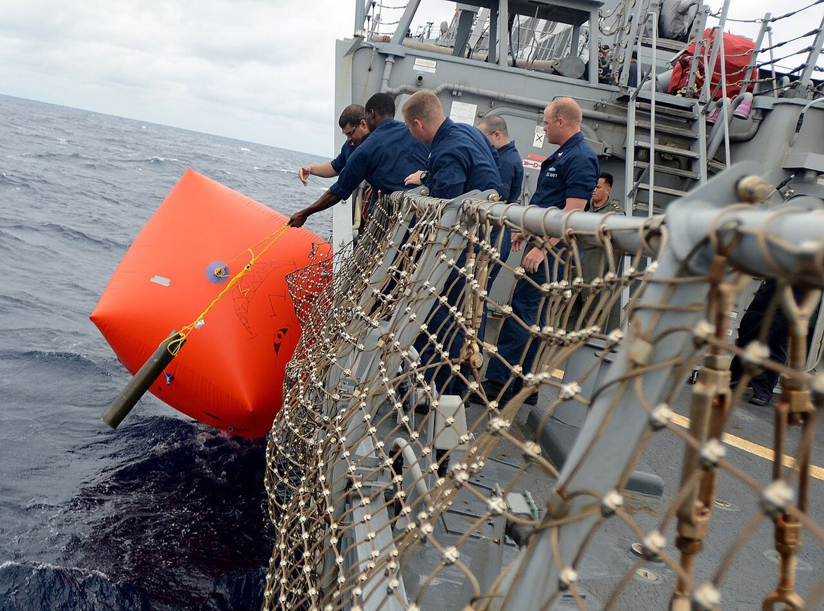 Sailors place target in water aboard USS Fitzgerald.